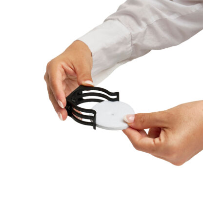 A person in a white long-sleeve shirt inserts a round white filter pad into the black holder from the Fresh & EZ Combo Kit, against a white background.